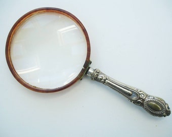 Magnifying glass in hand and old silver coins Stock Photo by ©sementer  20320255