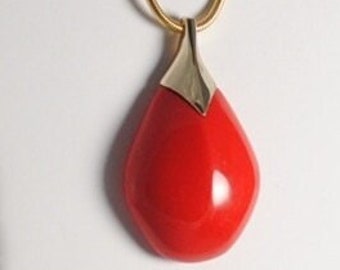 May include: A gold chain necklace with a red teardrop-shaped pendant.