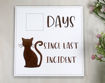 May include: White sign with a brown silhouette of a cat and the text "DAYS SINCE LAST INCIDENT".