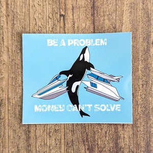 May include: A blue sticker with a black and white orca whale jumping over two white speedboats. The text "BE A PROBLEM MONEY CAN'T SOLVE" is printed on the sticker.