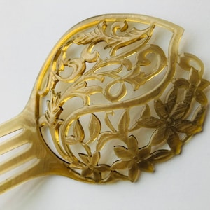 Clear watermarked antique hair comb with floral cutout design