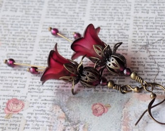 May include: Burgundy flower-shaped earrings with ornate bronze accents and dangling beads.