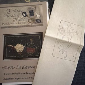 May include: A punch needle craft kit featuring a pattern booklet titled With thy Needle & Thread Punchneedle Designs by Brenda Gervais, showing a goose and Christmas tree, alongside a piece of off-white fabric with the same design printed on it.