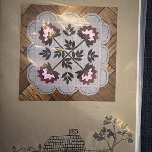 May include: A craft pattern titled Pretty Peonies featuring a square quilt block with scalloped edges, dark green leaves, and maroon and pink flowers. Below, a line drawing shows a cottage, a tree, and a sign reading The Cottage at Cardiff Farms.