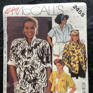 May include: A sewing pattern for tops, featuring a black and white zebra print, a yellow and green floral print, and a blue and white polka dot print. The pattern is for sizes extra small and is from McCall's.
