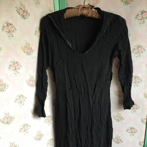 May include: A black long-sleeved dress with a zipper detail at the neckline.