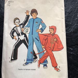 May include: Simplicity sewing pattern number 6696 for a boy's costume. The pattern includes three costumes: a skeleton, an astronaut, and a devil. The pattern is for sizes 7-8 and includes transfers for appliques.