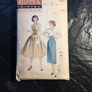 May include: Vintage sewing pattern for a dress, Butterick pattern number 6482, size 10, bust 28. The pattern shows two different styles of dresses, one with a plaid print and the other in a solid blue color. The pattern is priced at 45 cents.