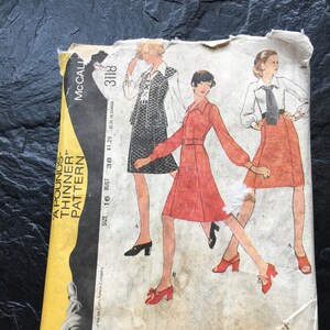 May include: Vintage McCall's sewing pattern envelope for a dress and skirt. The envelope is yellow with black text and features a drawing of three women wearing the pattern's designs. The text on the envelope reads "A Pounds-Thinner Pattern" and "Size 16 Bust 38 $1.25 $1.35 in Canada 3118".