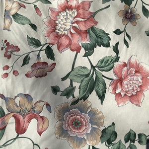 May include: A floral pattern fabric with pink, white, and green flowers. The fabric has a cream background.
