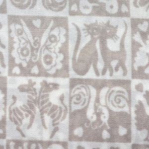 May include: White fabric with a repeating pattern of brown stylized animal and floral designs. The fabric has a subtle texture.