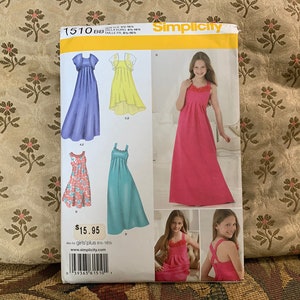 May include: Simplicity sewing pattern 1510BB for girls plus sizes 8-16. The pattern includes instructions and diagrams for making four different styles of maxi dresses. The dresses are shown in blue, yellow, teal, pink, and red.
