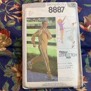 May include: Simplicity sewing pattern number 8887 for a knit top and pants. The pattern is for size 14 (misses). The pattern cover features a woman wearing a brown knit top and pants, and two women wearing knit tops and shorts. The pattern is for "Tiger Stretch Knit" fabric.