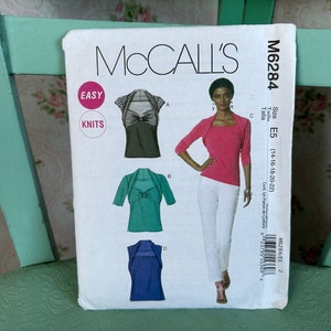 May include: A McCall's sewing pattern for a knit top with a square neckline and a bow detail. The pattern is for sizes E5 (14-16-18-20-22). The pattern is labeled "Easy Knits".