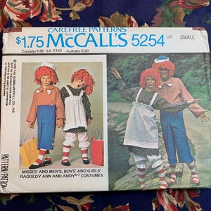 May include: A vintage sewing pattern for Raggedy Ann and Andy costumes. The pattern is from McCall's and is size small. The pattern cover features a photo of two children dressed as Raggedy Ann and Andy.