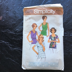 May include: Vintage Simplicity sewing pattern number 6975 for a simple-to-sew top. The pattern includes four different styles of tops, with one featuring a floral print. The pattern is for sizes 38 to 42.