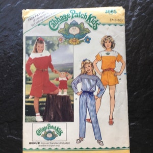 May include: A vintage sewing pattern for Cabbage Patch Kids clothing. The pattern includes three different outfits: a red and white striped jumpsuit, a yellow and white striped jumpsuit, and a red and white striped dress with a matching headband. The pattern is for sizes 7-8-10 and includes iron-on transfers.