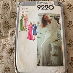 May include: Simplicity sewing pattern number 9220 for a robe. The pattern includes two sizes, 18 and 20, for misses. The pattern shows a white robe with a long, flowing design. The pattern also includes a picture of a woman wearing the robe.