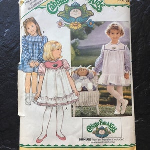 May include: A vintage sewing pattern for Cabbage Patch Kids clothing. The pattern is for sizes 5-6-6x and includes two dress designs. The pattern is from Butterick and includes iron-on transfers.