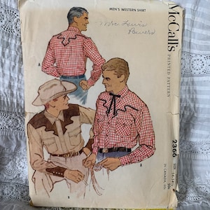 May include: Vintage McCall's sewing pattern for a men's Western shirt. The pattern is for sizes 14-14 1/2 and features a red and white gingham shirt with a brown leather yoke and a tan shirt with a brown leather yoke. The pattern is titled "Men's Western Shirt" and the number 2366 is printed on the front.