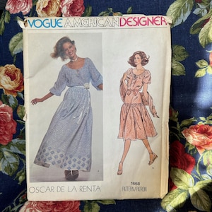 May include: Vintage Vogue American Designer sewing pattern number 1668 for a dress by Oscar de la Renta. The pattern features two different styles of a dress, one with a long skirt and one with a shorter skirt. Both dresses have a scoop neck, puff sleeves, and a tie belt.