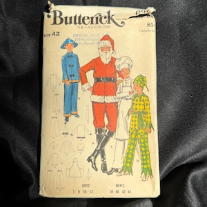 May include: Vintage Butterick sewing pattern featuring illustrations of Santa Claus, a chef, and a jester. The pattern includes sizes for boys and men. The cover is cream-colored with the text "Butterick" and "The Fashion One".