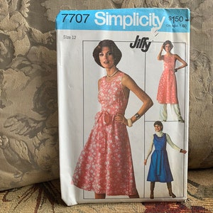 Può includere: Modello di cucito Simplicity numero 7707, Jiffy, taglia 12, per un abito floreale rosa con un fiocco in vita. Il modello include tre diverse viste dell'abito.