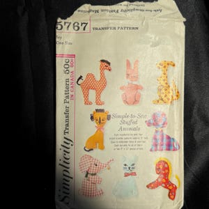 May include: Vintage Simplicity transfer pattern for simple-to-sew stuffed animals. The pattern features eight toy animal designs, including a camel, rabbit, kangaroo, lion, poodle, elephant, cat, and horse. The pattern is marked "5767" and "One Size".