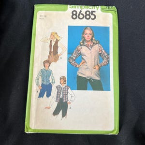 May include: Simplicity sewing pattern number 8685 for a vest. The pattern shows four different styles of vests, including a plaid vest, a brown vest, and a white vest. The pattern is for misses sizes 12.
