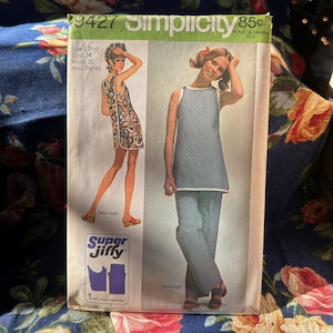 Może przedstawiać: Wzór szycia Simplicity numer 9427 na tunikę i spodnie. Wzór jest dla rozmiarów 12mp, biust 86 cm, talia 66 cm. Wzór przedstawia modelkę w tunice i spodniach w czarno-białe kropki. Wzór jest oznaczony jako "Super Jiffy" i zawiera instrukcje do wykonania odzieży.