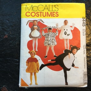 May include: A sewing pattern for children's costumes. The pattern includes four costumes: a ghost, a dalmatian, a puppy, and a bear. The pattern is from McCall's Costumes and is size Ex-Small (Toute Petite).