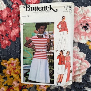 May include: A vintage Butterick sewing pattern, size 12, showing a woman in a red and white striped top and white skirt. The pattern includes illustrations of different outfits, such as a jacket and trousers ensemble.