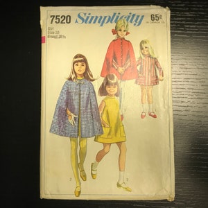 May include: Simplicity sewing pattern number 7520 for girls' capes and dresses. The pattern includes three different styles: a red cape, a blue and white plaid cape, and a yellow dress. The pattern is for sizes 10 with a 28 1/2 inch bust.