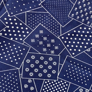May include: A blue fabric with a repeating pattern of white polka dots, flowers, and geometric shapes.