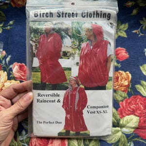 May include: A package for a reversible red raincoat and companion vest from Birch Street Clothing. The package shows the raincoat and vest being worn. The text on the package reads "Reversible Raincoat & The Perfect Duo" and "Companion Vest XS-XL."