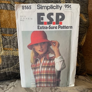May include: Simplicity sewing pattern 8165 featuring a woman wearing a red hat and plaid vest. The pattern is labeled "ESP Extra-Sure Pattern" and includes sizing information. The price is listed as 95¢.