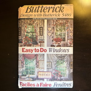 Peut inclure: Un livre de patrons de couture Butterick vintage pour la décoration de la maison, avec le titre "Easy to Do Windows" et le numéro 5480. La couverture montre quatre traitements de fenêtres différents avec du tissu et du papier peint à motifs floraux.