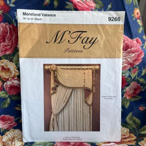 May include: A M'Fay Patterns sewing envelope for a Moreland Valance, model 9266, with a 40.6 to 55.9 cm depth. The cover features a photograph of a beige, draped window valance with decorative tassels, fringe trim, and buttons on a curtain rod.