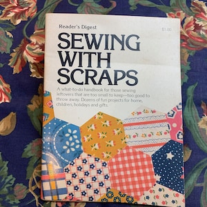 Pode incluir: Um livro vintage da Reader's Digest intitulado "Sewing With Scraps" com um preço de $ 1,00. A capa apresenta um cobertor de retalhos colorido feito de retalhos de tecido.