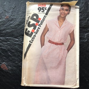 May include: A vintage Simplicity sewing pattern for a striped dress with a collar and short sleeves. The pattern number is 9428 and the price is 95 cents. The pattern is for an Extra-Sure pattern.