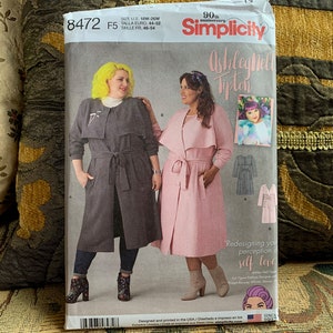 May include: A Simplicity sewing pattern for a women's trench coat. The pattern is for sizes 14-20. The pattern is called "Ashley Nell Tipton" and features a pink and a gray trench coat.