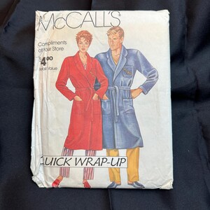 Può includere: Un modello di cucito vintage McCall's per una vestaglia a intreccio rapido. Il modello presenta due manichini che indossano vestaglie, una rossa e una blu. Il modello è intitolato "Quick Wrap-Up" e include il testo "Compliments of your store $ 4.00 valore di vendita al dettaglio."