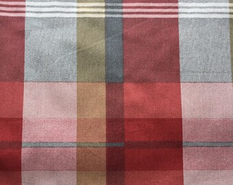 May include: A red, pink, grey, and brown plaid fabric with a woven texture.