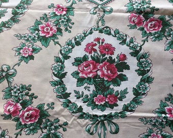 May include: A white fabric with a repeating pattern of pink and green floral designs. The floral designs feature pink roses, green leaves, and white flowers. The fabric has a vintage aesthetic.