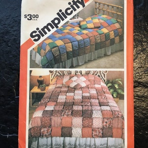 May include: Simplicity sewing pattern number 5703 for a patchwork quilt. The pattern shows two quilts, one in red, brown, and white, and the other in blue, green, yellow, and brown. The pattern is $3.00.