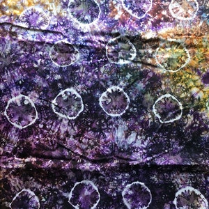 May include: Purple and yellow tie-dye fabric with a white circle pattern.