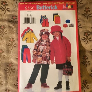 May include: A sewing pattern for children's clothing, Butterick pattern number 6366, sizes 2-3-4-5. The pattern includes a red fleece jacket, a brown teddy bear print jacket, a red hat, a brown hat, a pair of red pants, a pair of black pants, a red vest, a blue vest, a black skirt, a red skirt, and a plaid bag.