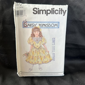 May include: Simplicity sewing pattern for a girl's dress, featuring a yellow dress with floral print and puffed sleeves. The pattern is titled "Daisy Kingdom" and is for sizes 7, 8, 10.