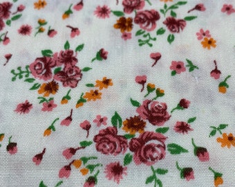 May include: White fabric with a repeating pattern of pink, orange, and green floral designs. The fabric has a subtle texture.