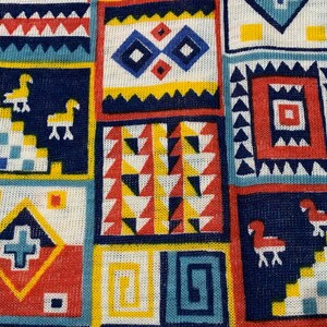 Peut inclure: Un tissu coloré avec un motif géométrique. Le motif comprend des carrés, des triangles et des losanges dans des tons de rouge, bleu, jaune et blanc.
